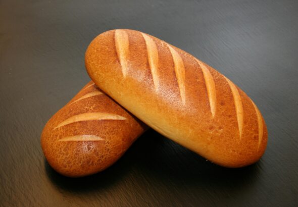 Close-up of two freshly baked loaves with crispy crust, ideal for food and still life photography.