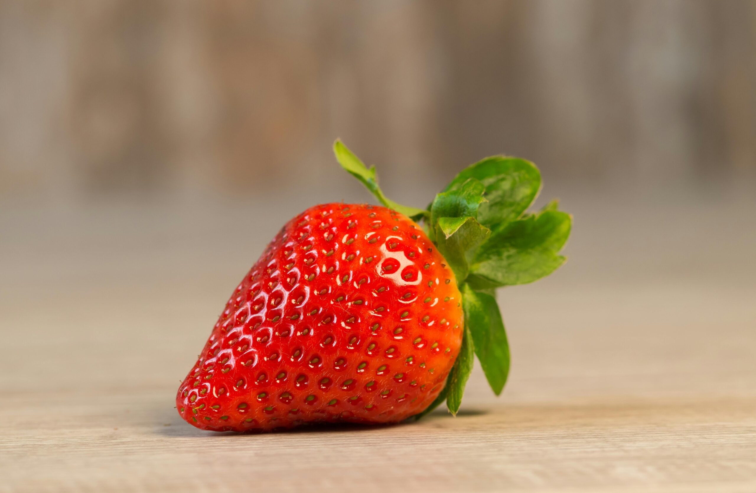 A vibrant close-up of a single, ripe strawberry showcasing freshness and vivid color.